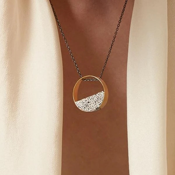 Close-up of a gold-plated pendant necklace featuring a handcrafted terrazzo inlay suspended from a delicate chain.